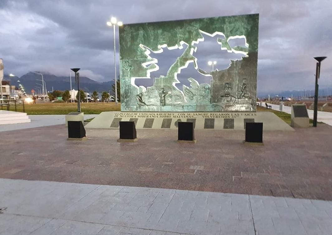 Foto con día nublado e iluminado con luces del muro en homenaje a los caídos en la Guerra de Malvinas en Ushuaia