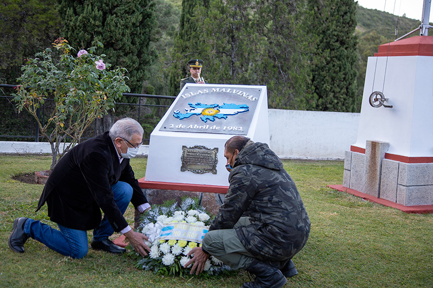 La fotografía muestra a dos Veteranos de la Guerra de Malvinas colocando ofrenda floral.