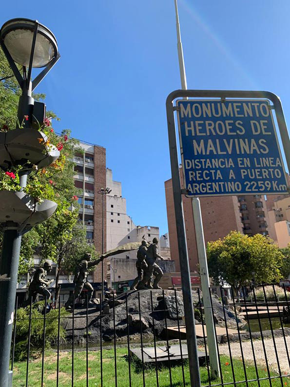 La fotografía muestra lo que dice un cartel exterior, indicando el nombre del monumento a los que combatieron en la Guerra de Malvinas, llamado “Héroes de Malvinas”.