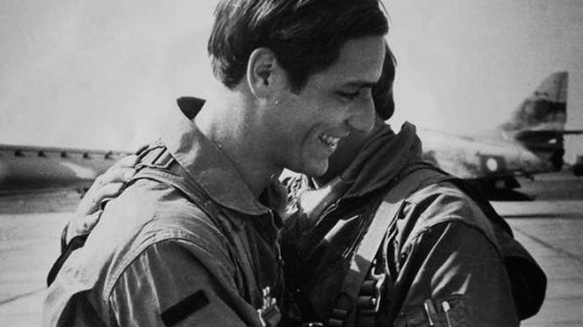La fotografía muestra al Capitán Aviador Omar Jesús Castillo abrazándose con otro camarada en la pista de un aeropuerto, con un avión de combate de fondo.