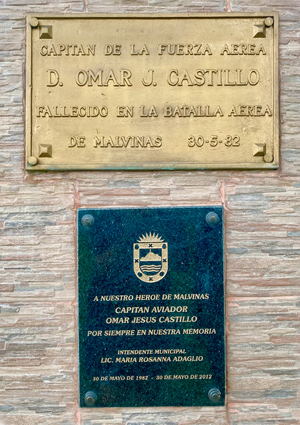 La fotografía muestra dos placas que se encuentran debajo del busto en homenaje al Capitán Aviador Omar Jesús Castillo.