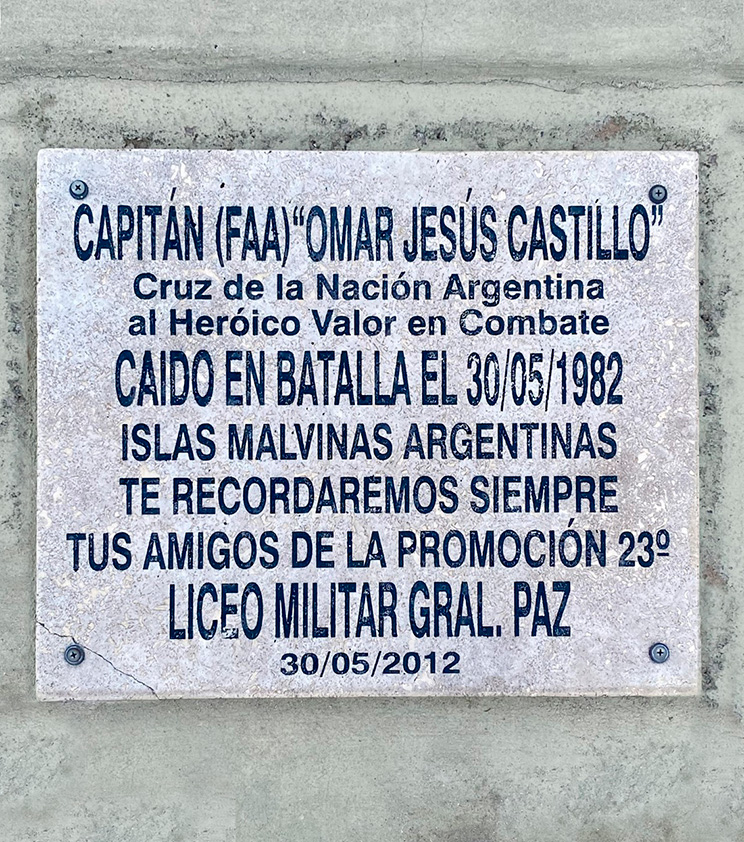 La fotografía muestra una placa destacando la obtención de la “Curz de la Nación Argentina al Heróico Valor en Combate” en homenaje al Capitán Aviador Omar Jesús Castillo dedicada por sus amigos de la promoción 23° del Liceo Militar General Paz.